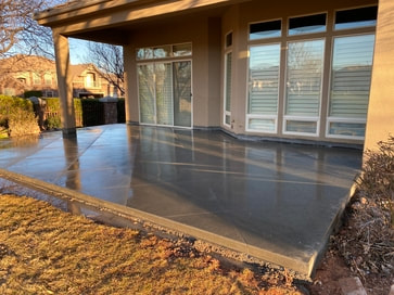 decorative concrete patio in the back of a house